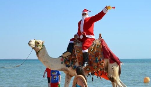 Netradiční Santa na velbloudu na poušti.